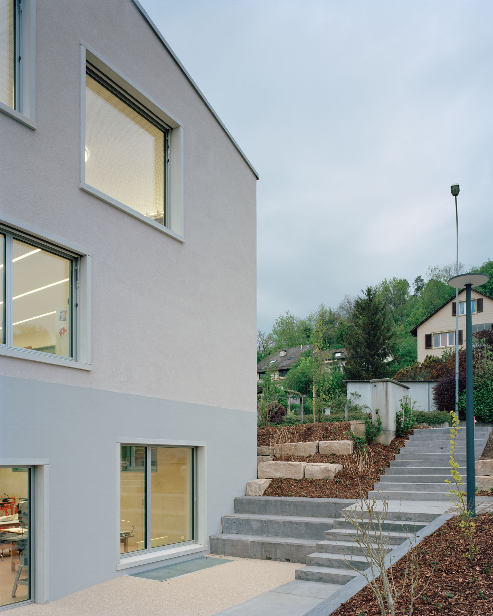 Analog architectural photography and documentation of the exterior of the school building in Birmenstorf, Switzerland, designed by MIDERI & HAFO. Photographed by Piotr Hraptovich, architectural photographer based in Basel, Switzerland. Analoge Architekturfotografie und Dokumentation der Aussensicht des Schulgebäudes in Birmenstorf, Schweiz, entworfen von MIDERI & HAFO. Fotografiert von Piotr Hraptovich, Architekturfotograf mit Sitz in Basel, Schweiz. 