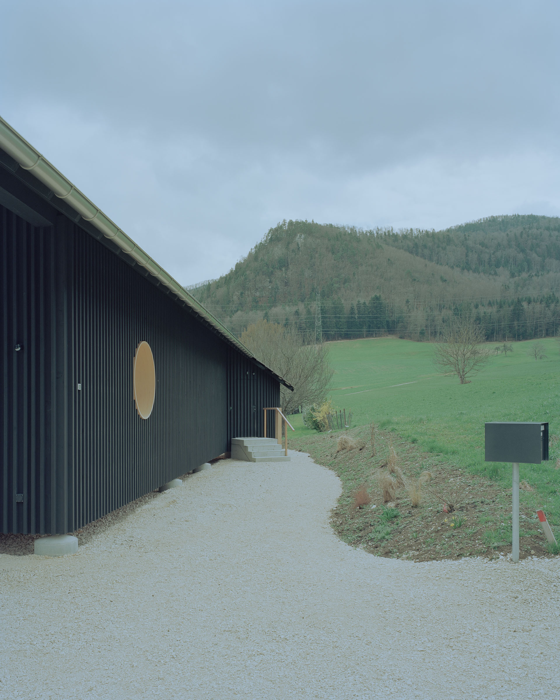 Analog architectural photography and documentation of the exterior of a single-family house in Vermes, Switzerland, designed by Hörner Oprea. Photographed by Piotr Hraptovich, architectural photographer based in Basel, Switzerland. Analoge Architekturfotografie und Dokumentation der Aussensicht eines Einfamilienhauses in Vermes, Schweiz, entworfen von Hörner Oprea. Fotografiert von Piotr Hraptovich, Architekturfotograf mit Sitz in Basel, Schweiz. 
