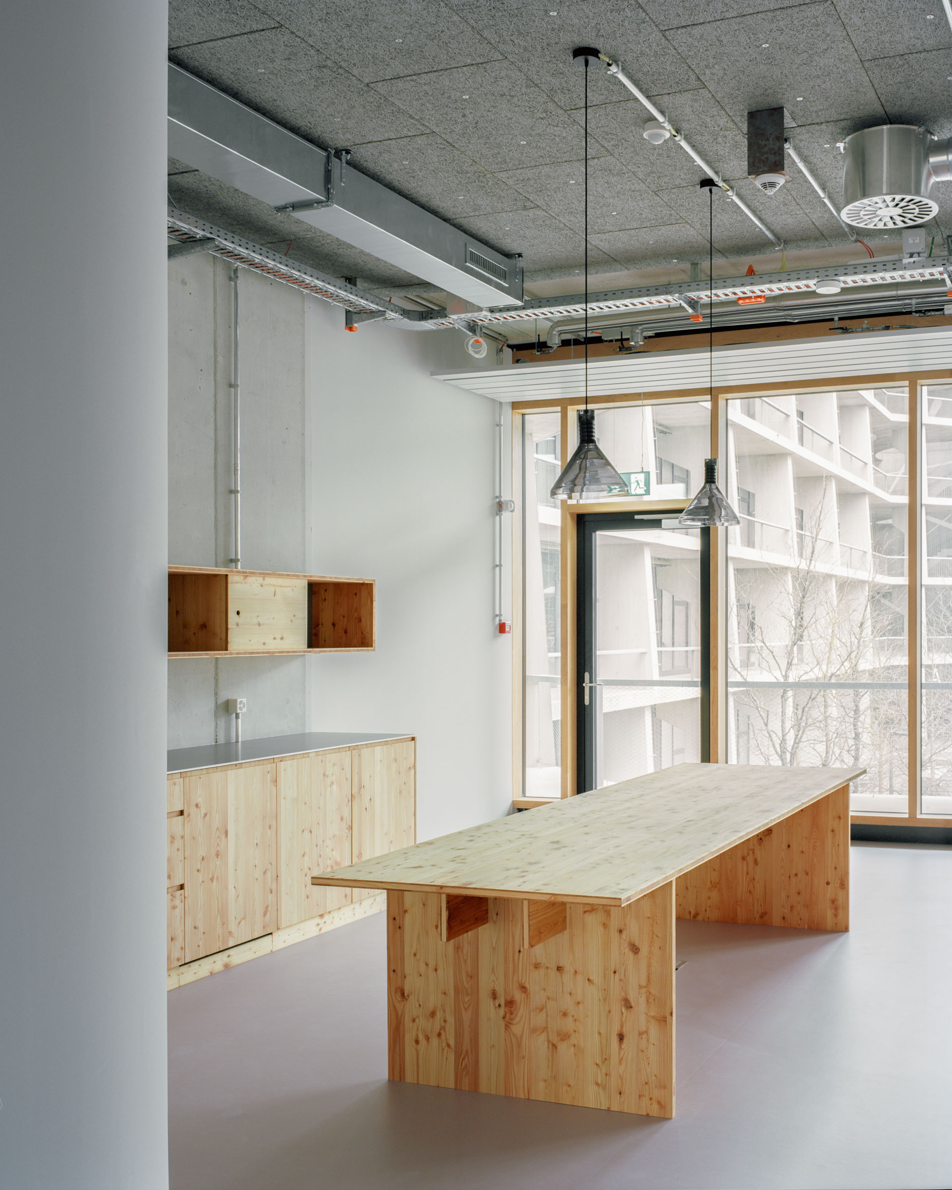 Analog architectural photography and documentation of the interior of Arcondis Headquarters, an open-office workspace in Basel, Switzerland. Designed by Sedano Architecture in collaboration with Studio Beat Egli, the project preserves the raw concrete and wood materiality of the Herzog & de Meuron building, creating a space that fosters collaboration and continuity between interior and exterior. Photographed by Piotr Hraptovich, architectural photographer based in Basel, Switzerland. Analoge Architekturfotografie und Dokumentation der Innenräume des Arcondis Headquarters, einem Open-Office-Arbeitsplatz in Basel, Schweiz. Entworfen von Sedano Architecture in Zusammenarbeit mit Studio Beat Egli, bewahrt das Projekt die rohe Materialität von Beton und Holz des Herzog & de Meuron Gebäudes und schafft einen Raum, der Zusammenarbeit und Kontinuität zwischen Innen- und Aussenraum fördert. Fotografiert von Piotr Hraptovich, Architekturfotograf mit Sitz in Basel, Schweiz. 