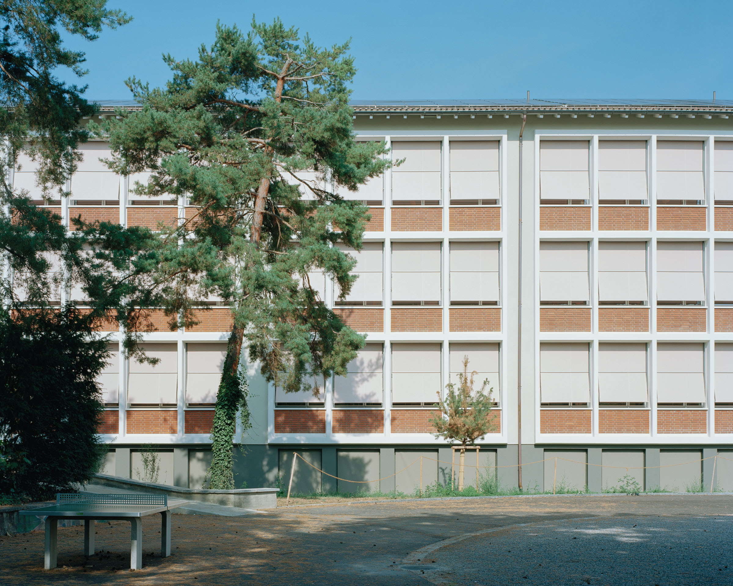 Analog architectural photography and documentation of the exterior façade of the Gellert School Complex in Basel, Switzerland, designed by MET Architects. Photographed by Piotr Hraptovich, architectural photographer based in Basel, Switzerland. Analoge Architekturfotografie und Dokumentation der Aussenfassade der Schulanlage Gellert in Basel, Schweiz, entworfen von MET Architects. Fotografiert von Piotr Hraptovich, Architekturfotograf mit Sitz in Basel, Schweiz. 