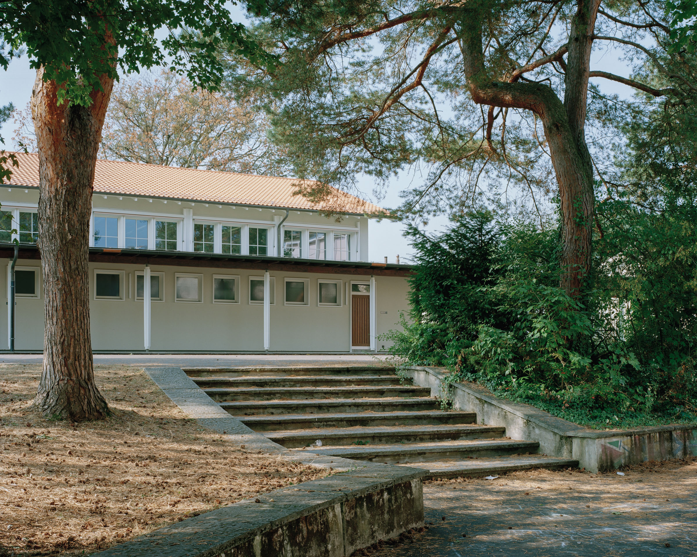 Analog architectural photography and documentation of the exterior façade of the Gellert School Complex in Basel, Switzerland, designed by MET Architects. Photographed by Piotr Hraptovich, architectural photographer based in Basel, Switzerland. Analoge Architekturfotografie und Dokumentation der Aussenfassade der Schulanlage Gellert in Basel, Schweiz, entworfen von MET Architects. Fotografiert von Piotr Hraptovich, Architekturfotograf mit Sitz in Basel, Schweiz. 