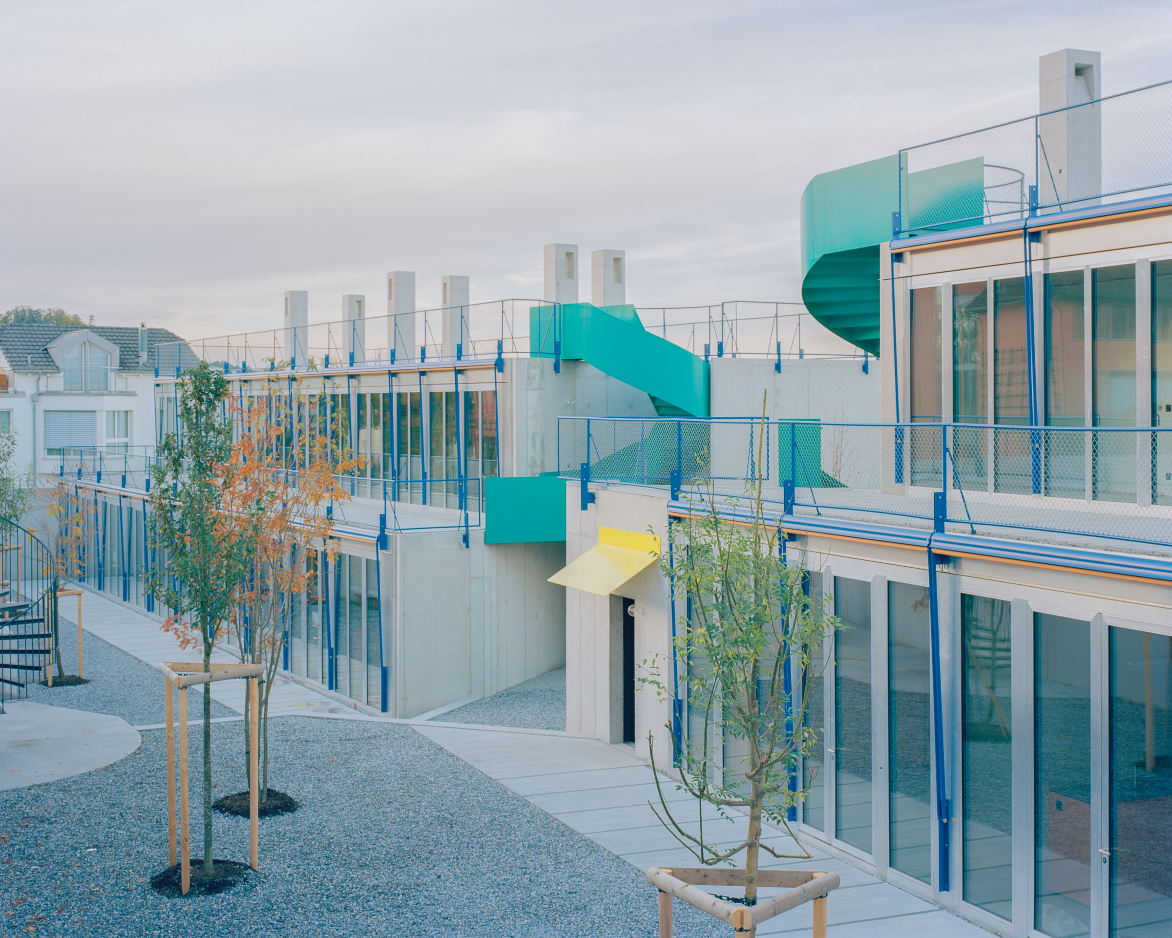Analog architectural photography and documentation of the exterior of the Roetiboden residential development in Wädenswil, Switzerland, designed by Buchner Bründler. Photographed by Piotr Hraptovich, architectural photographer based in Basel, Switzerland. Analoge Architekturfotografie und Dokumentation der Aussensicht der Wohnüberbauung Rötiboden in Wädenswil, Schweiz, entworfen von Buchner Bründler. Fotografiert von Piotr Hraptovich, Architekturfotograf mit Sitz in Basel, Schweiz. 