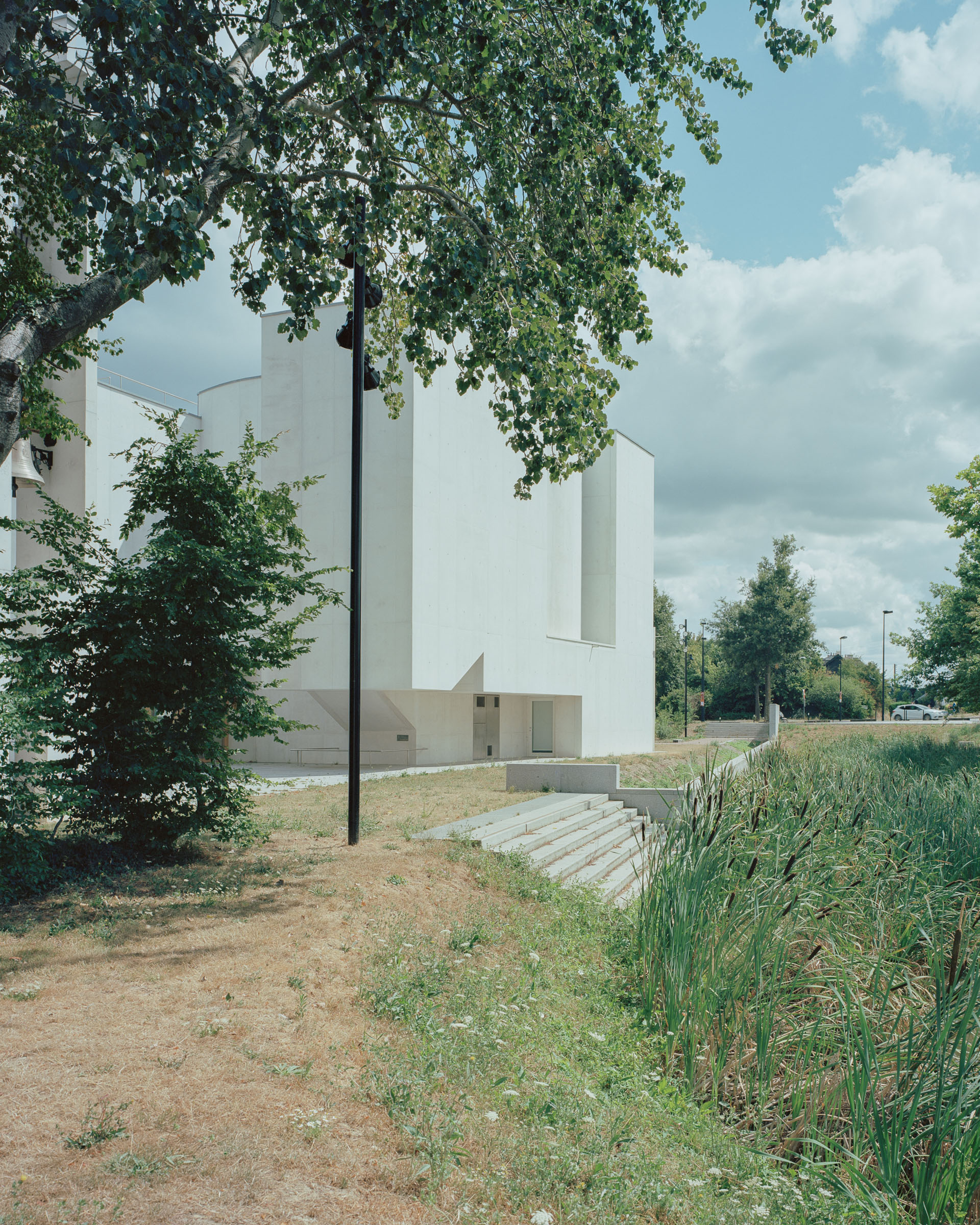 Analog architectural photography and documentation of the exterior of the Church of Saint‑Jacques‑de‑la‑Lande, located in Brittany, France, designed by Álvaro Siza. Photographed by Piotr Hraptovich, architectural photographer based in Basel, Switzerland. Analoge Architekturfotografie und Dokumentation der Aussensicht der Kirche Saint‑Jacques‑de‑la‑Lande in der Bretagne, Frankreich, entworfen von Álvaro Siza. Fotografiert von Piotr Hraptovich, Architekturfotograf mit Sitz in Basel, Schweiz. 