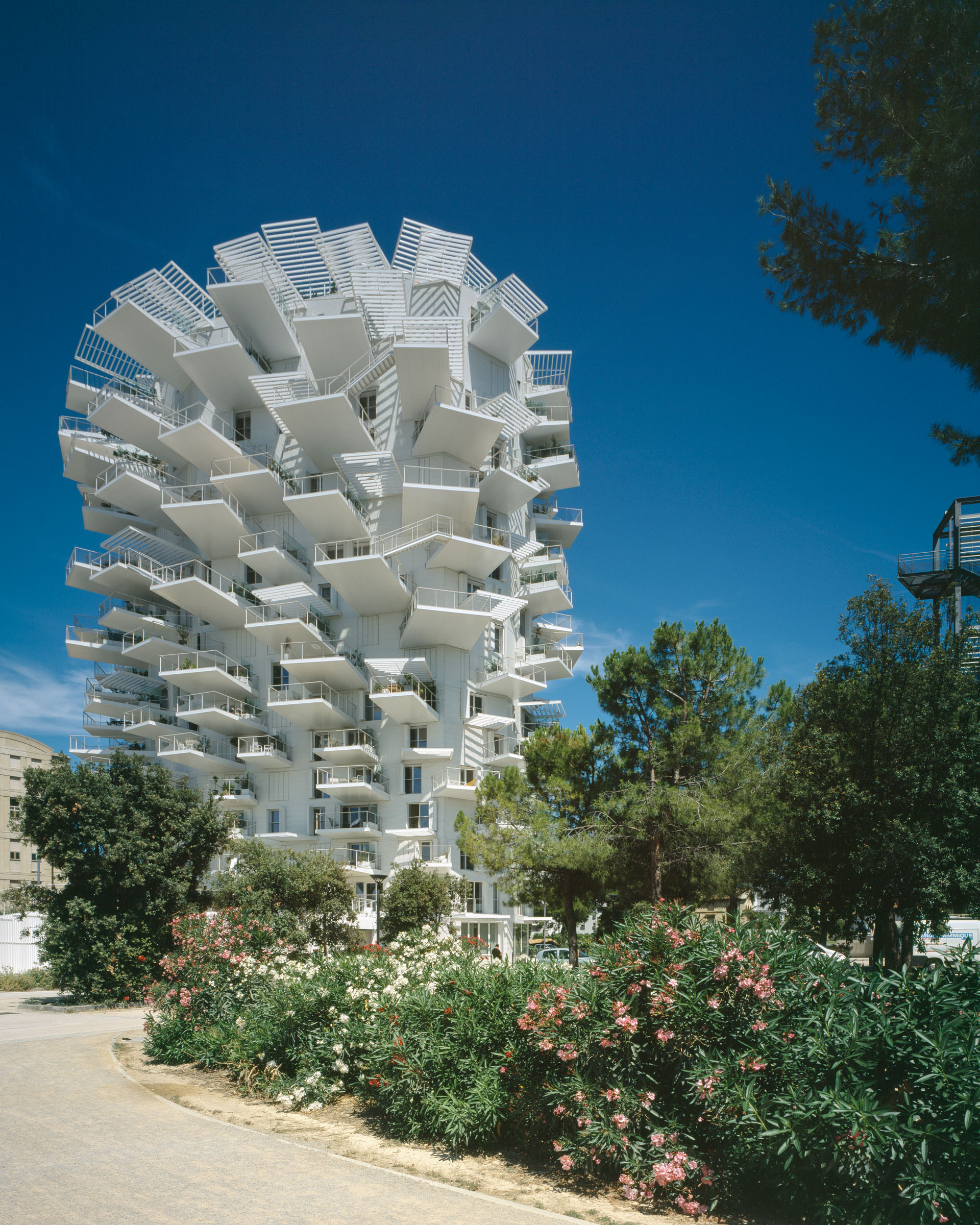 Analog architectural photography and documentation of the exterior of L’Arbre Blanc residential tower in Montpellier, France, designed by Sou Fujimoto in collaboration with Nicolas Laisné and Manal Rachdi (OXO Architects). Photographed by Piotr Hraptovich, architectural photographer based in Basel, Switzerland. Analoge Architekturfotografie und Dokumentation der Aussensicht des Wohnhochhauses L’Arbre Blanc in Montpellier, Frankreich, entworfen von Sou Fujimoto in Zusammenarbeit mit Nicolas Laisné und Manal Rachdi (OXO Architects). Fotografiert von Piotr Hraptovich, Architekturfotograf mit Sitz in Basel, Schweiz. 