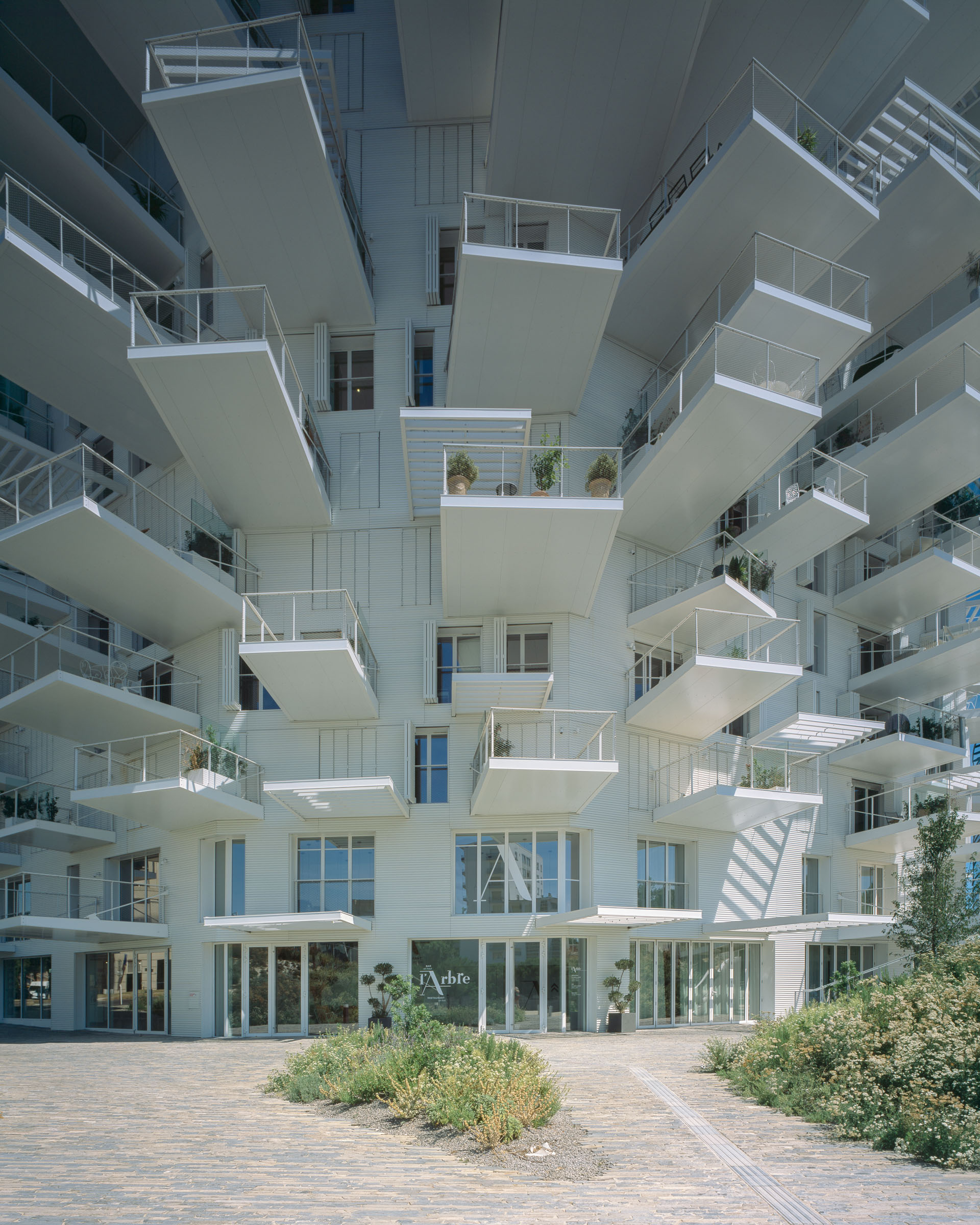 Analog architectural photography and documentation of the exterior of L’Arbre Blanc residential tower in Montpellier, France, designed by Sou Fujimoto in collaboration with Nicolas Laisné and Manal Rachdi (OXO Architects). Photographed by Piotr Hraptovich, architectural photographer based in Basel, Switzerland. Analoge Architekturfotografie und Dokumentation der Aussensicht des Wohnhochhauses L’Arbre Blanc in Montpellier, Frankreich, entworfen von Sou Fujimoto in Zusammenarbeit mit Nicolas Laisné und Manal Rachdi (OXO Architects). Fotografiert von Piotr Hraptovich, Architekturfotograf mit Sitz in Basel, Schweiz. 